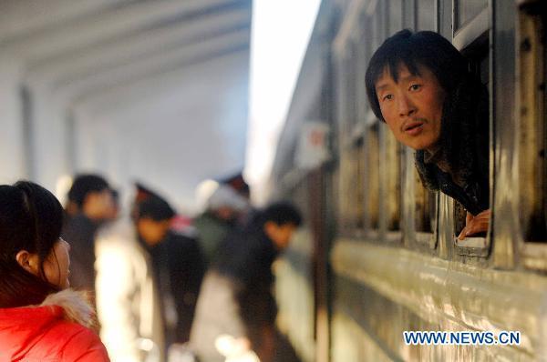 A passenger looks outside a train at Yinchuan Railway Station in Yinchuan City, northwest China&apos;s Ningxia Hui Autonomous Region, on Jan. 13, 2011. Additional trains were opened to the public at the station in order to ease the pressure of the upcoming Spring Festival travel season. [Xinhua]