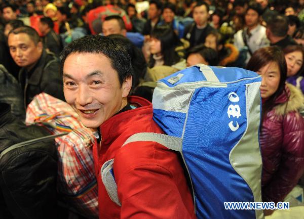 Migrant worker Shen Shuwen from southwest China&apos;s Chongqing is seen in Fuzhou Railway Station in Fuzhou, southeast China&apos;s Fujian Province, Jan. 13, 2011. A total of 1,936 migrant workers began their journey home on Temporary Train L390, the first special train for migrant workers in Fuzhou Railway Station during the Spring Festival travel of 2011. [Xinhua]