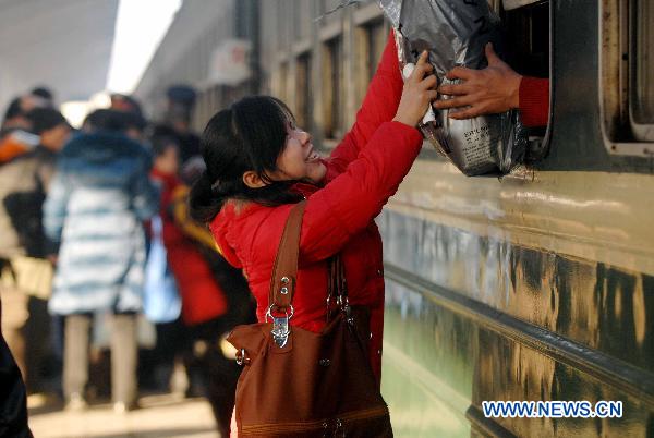 A woman hands over a package at Yinchuan Railway Station in Yinchuan City, northwest China&apos;s Ningxia Hui Autonomous Region, on Jan. 13, 2011. Additional trains were opened to the public at the station in order to ease the pressure of the upcoming Spring Festival travel season. [Xinhua]