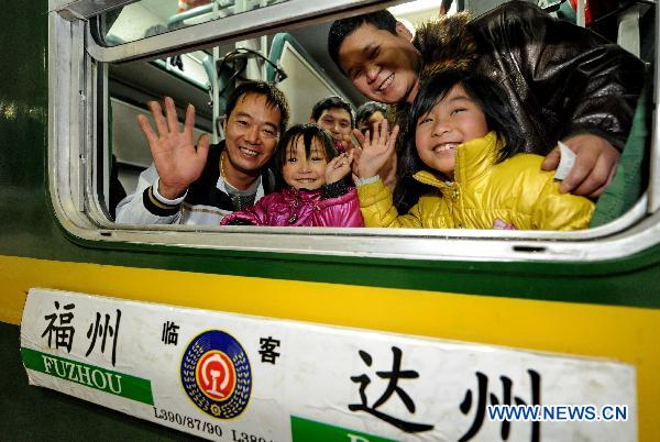 Migrant workers from southwest China&apos;s Sichuan Province, together with their children, wave goodbye in Fuzhou Railway Station in Fuzhou, southeast China&apos;s Fujian Province, Jan. 13, 2011. A total of 1,936 migrant workers began their journey home on Temporary Train L390, the first special train for migrant workers in Fuzhou Railway Station during the Spring Festival travel of 2011. [Xinhua]