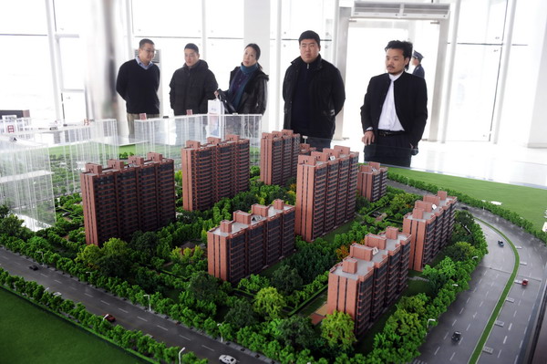 Residents look over a model of the Sunny Paradise subsidized housing project on Nov 25, 2009. 