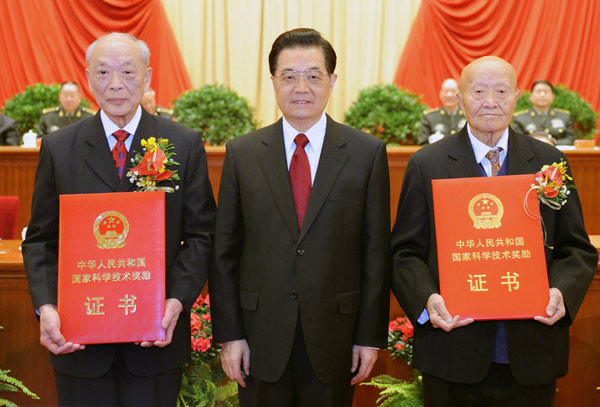 President Hu Jintao (C) poses for photos with China's State Top Scientific and Technological Award winners Shi Changxu (R) and Wang Zhenyi (L) at the Great Hall of the People in Beijing, Jan 14, 2011.