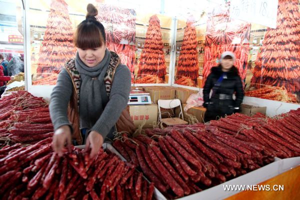 An employee arranges sausages in a market in Yangzhou, east China's Jiangsu Province, Jan. 14, 2011. People started to do Spring Festival purchase for the upcoming Chinese Lunar New Year. (Xinhua/Zhang Bingtao) (ly) 