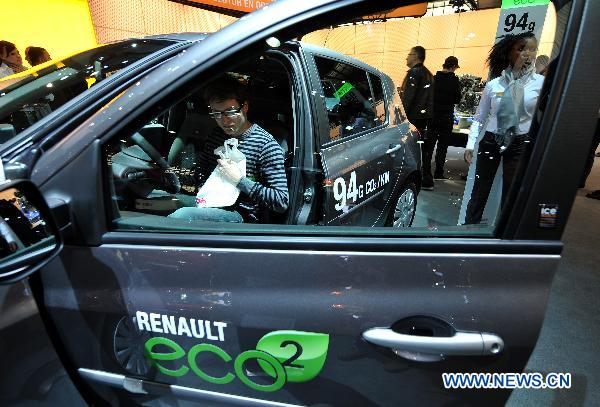 A visitor experiences Renault's low emission vehicle during the first day of the 89th European Motorshow in Brussels, capital of Belgium, Jan. 15, 2011.