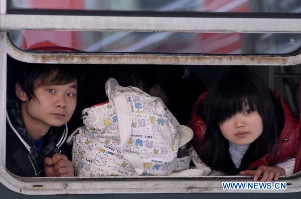 Photo taken on Jan. 15, 2011 shows two passengers on the train in Nanjing, capital of east China&apos;s Jiangsu Province.