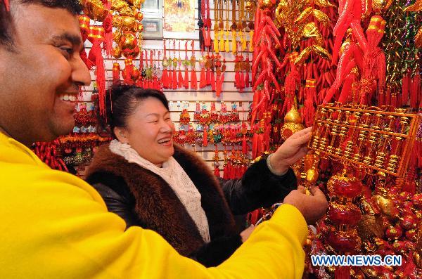 Indian businessman Amjed Khan (L) buys a golden abacus symbolizing good fortune in Yiwu Merchandise Market in east China's Zhejiang Province, Jan. 16, 2011. 