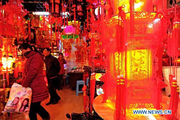 Two buyers from east China's Jiangsu Province select archaized palace lanterns in Yiwu Merchandise Market in east China's Zhejiang Province, Jan. 16, 2011. 