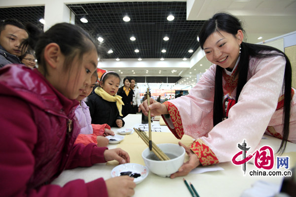 Children learn calligraphy on Thursday at the book fair&apos;s opening. [China.com.cn] 