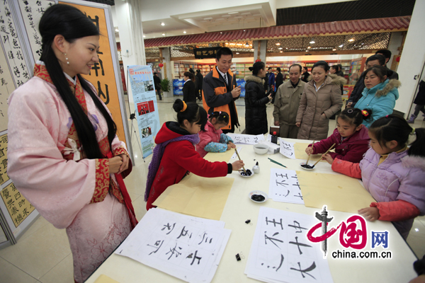 Children learn calligraphy on Thursday at the book fair&apos;s opening. [China.com.cn]
