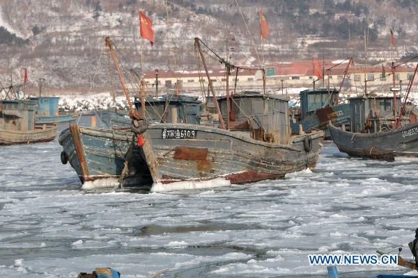 Fishing boats are seen stranded in the iced surface at Zhifu Island in eastern China&apos;s Shandong Province, Jan. 17, 2011. The thickness of the freezing ice has amounted to 15 to 20 centimeters due to continuous cold waves while most offshore activities were forced to be halted. 