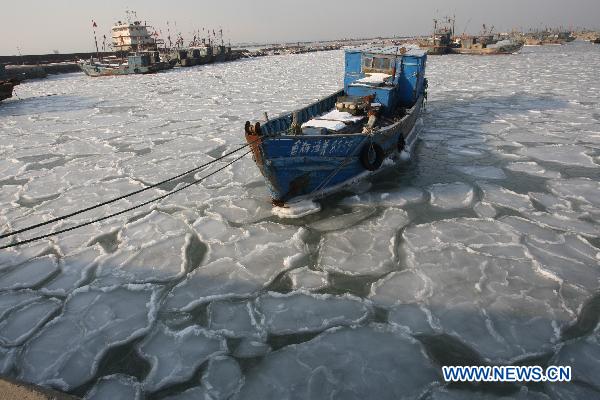 Fishing boats are seen stranded by ice at Zhifu Island in eastern China&apos;s Shandong Province, Jan. 17, 2011. The thickness of the freezing ice has amounted to 15 to 20 centimeters due to continuous cold waves while most offshore activities were forced to be halted. 