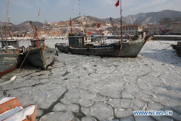 Fishing boats are seen stranded in the iced surface at Zhifu Island in eastern China&apos;s Shandong Province, Jan. 17, 2011. The thickness of the freezing ice has amounted to 15 to 20 centimeters due to continuous cold waves while most offshore activities were forced to be halted.