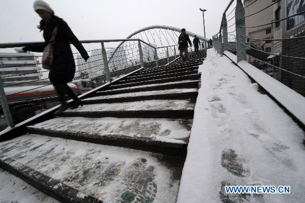 A pedestrian walks off an overpass in Guiyang, capital of southwest China&apos;s Guizhou Province, Jan. 17, 2011. Rain, snow and ice hit the province again from Jan. 16. The lowest temperature of the province dropped to minus 6.1 degrees Celsius at Weining County, which is located in the Wumeng mountain areas. 