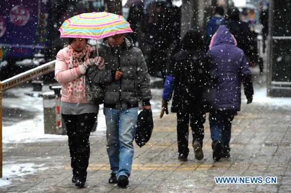A couple walk on a street in Guiyang, capital of southwest China&apos;s Guizhou Province, Jan. 17, 2011. 