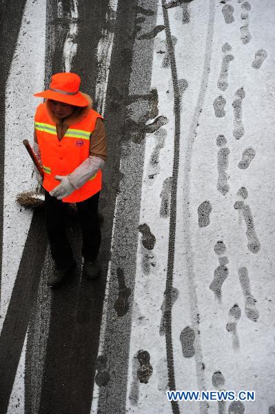 A sanitation worker is seen in Guiyang, capital of southwest China's Guizhou Province, Jan. 17, 2011. Rain, snow and ice hit the province again from Jan. 16. The lowest temperature of the province dropped to minus 6.1 degrees Celsius at Weining County, which is located in the Wumeng mountain areas. 