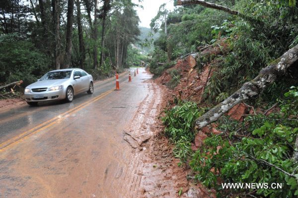 A car runs on the road damaged by the landslide in the mountain area of Teresopolis, Brazil, Jan. 16, 2011.