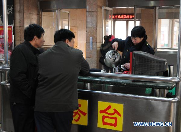 A staff member fills hot water for passengers at a railway station in Shijiazhuang, capital of north China's Hebei Province, Jan. 18, 2011. 