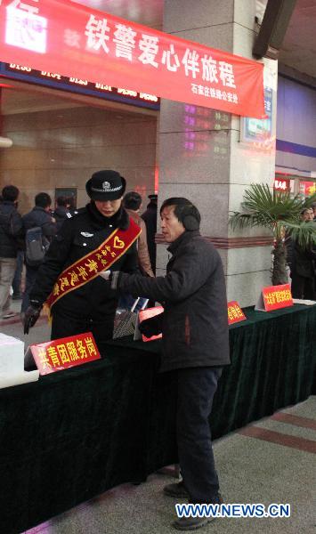 A staff member anwsers questions from a passenger at a railway station in Shijiazhuang, capital of north China's Hebei Province, Jan. 18, 2011. 