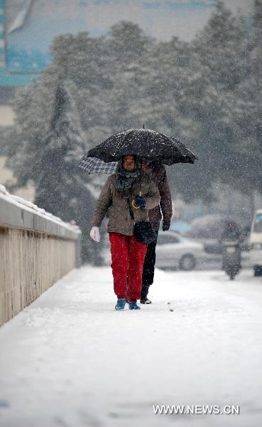 Citizens of Jiujiang in east China's Jiangxi Province walk in the heavy snow, Jan. 18, 2011. 