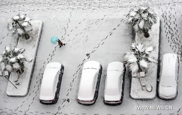 Photo taken on Jan. 18, 2011 shows vehicles covered with snow by the Changhong Avenue in Jiujiang, east China's Jiangxi Province.