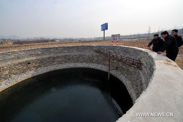 People check a well built for irrigation in Shuangquan Township of Changqing, Jinan, capital of east China's Shandong Province, Jan. 18, 2011. 