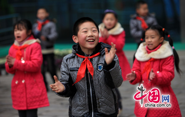 Children of migrant workers receive cotton-padded jackets as New Year&apos;s gifts at a primary school in Chongqing on Sunday. Meanwhile, 70 other outstanding students from poor families each get 1,000 yuan. [China.com.cn]