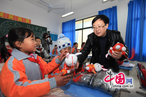 Children of migrant workers receive rabbit toys to celebrate the coming Year of the Rabbit. [China.com.cn]
