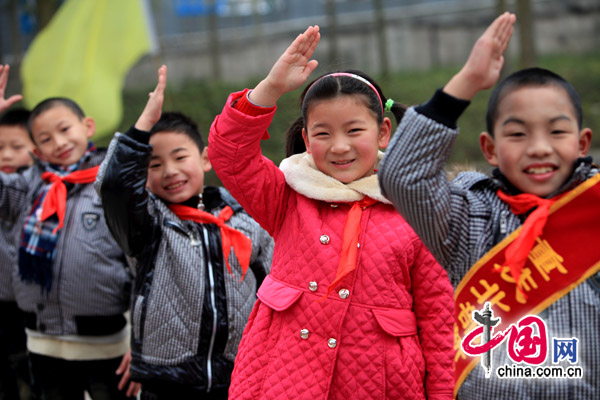 Children of migrant workers salute to thank a Chongqing primary school for their new jackets. [China.com.cn]