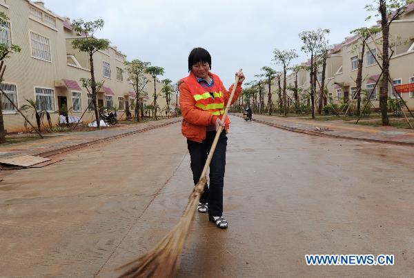 Gao Fenglan, a villager of Lushan Village works as a sanitation worker in the new residential area for moved villagers in Longlou Township of Wenchang, south China's Hainan Province, Jan. 12, 2011. 