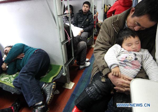 Passengers take a nap in a train setting out from east China's Shanghai, Jan. 19, 2011, the first day of the 40-day Spring Festival travel rush. 