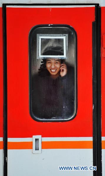 A passenger is seen on a train in Harbin Railway Station in Harbin, northeast China's Heilongjiang Province, Jan. 19, 2011, the first day of the 40-day Spring Festival travel rush. China's Ministry of Transport (MOT) estimated that 2.85 billion passenger trips would be made during the period, 11.6 percent more than last year.