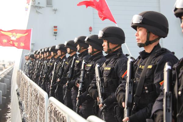 Soldiers stand guard on board and prepare to set sail at a port in Zhoushan, east China's Zhejiang Province, Feb. 21, 2011. 