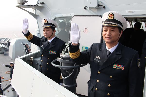 Officers wave hands on board and prepare to set sail at a port in Zhoushan, east China's Zhejiang Province, Feb. 21, 2011.