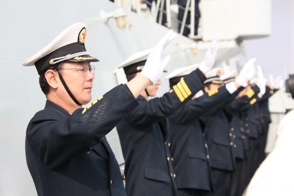 Officers wave hands on board and prepare to set sail at a port in Zhoushan, east China's Zhejiang Province, Feb. 21, 2011. 