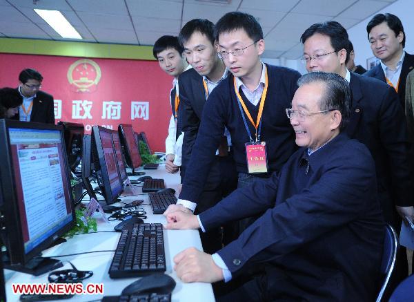 Chinese Premier Wen Jiabao (L, front) inspects the newsroom of the two state news portals, after finishing an online chat with Internet users in Beijing, capital of China, Feb. 27, 2011. 