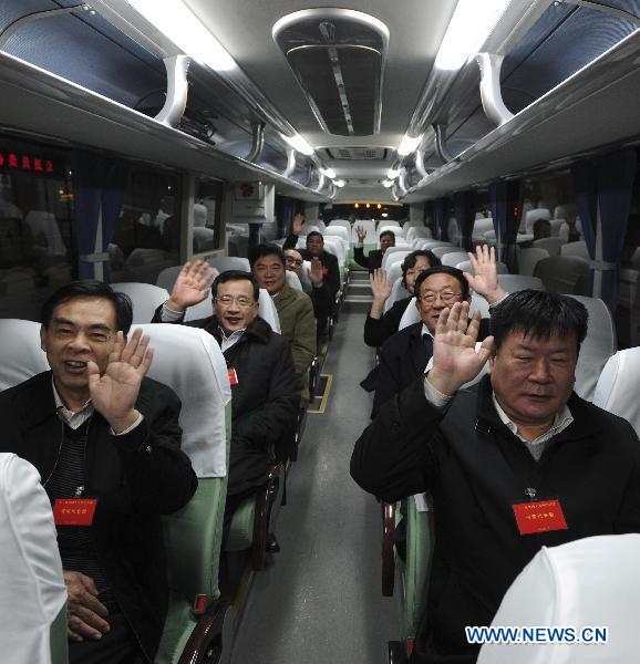Deputies to the Fourth Session of the 11th National People's Congress (NPC) from central China's Henan Province, gesture to journalists as they arrive in Beijing, capital of China, March 2, 2011. 
