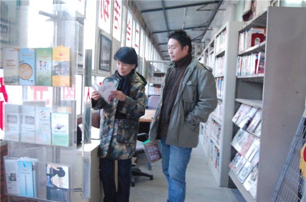 Ke Huixin (L), a member of the 11th National Committee of the Chinese People&apos;s Political Consultative Conference (CPPCC) and professor of the Communication University of China, visits the library in Migrant Workers Home, a nonprofit organization, in Picun Village in the northeastern suburbs of Beijing on March 2, 2011. 