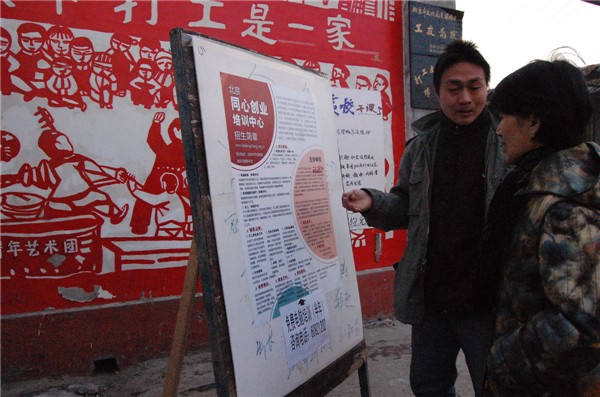 Sun Heng (L), founder and curator of the nonprofit Migrant Workers Home, shows the development of the organization’s training center to Ke Huixin (R), a member of the 11th National Committee of the Chinese People's Political Consultative Conference (CPPCC) and professor of the Communication University of China, in Picun Village in the northeastern suburbs of Beijing on March 2, 2011. 