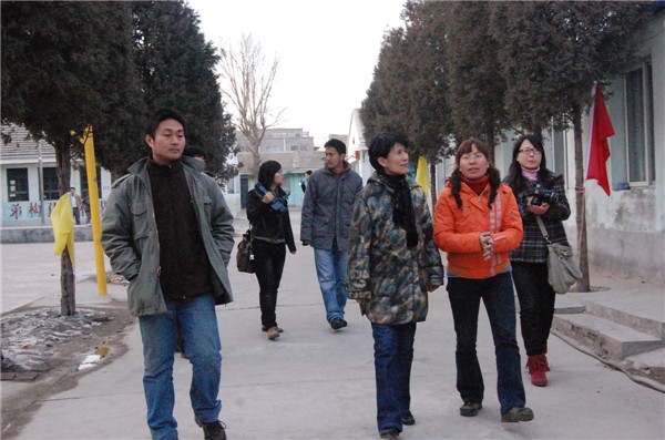 Shen Jinhua (2nd R), president of the Tongxin Experimental School, shows the campus to Ke Huixin (3rd R), a member of the 11th National Committee of the Chinese People's Political Consultative Conference (CPPCC) and professor of the Communication University of China, in Picun Village in the northeastern suburbs of Beijing on March 2, 2011. 