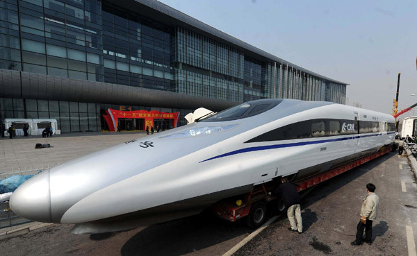 Workers at the China National Convention Center prepare to transport a locomotive of the domestically developed 'Harmony' bullet train to the square outside the center in Beijing, March 5, 2011.