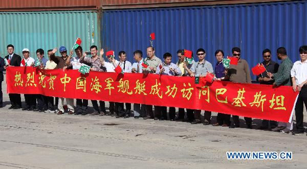 Chinese diplomats and delegates of the overseas Chinese wave flags during the farewell ceremony for the 8th escort flotilla sent by the Chinese Navy, in Karachi, Pakistan, March 13, 2011. 