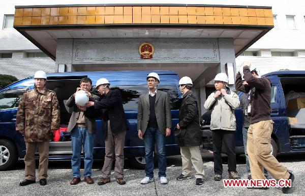 Members of the working group of the Chinese Embassy prepare themselves before their departure in Tokyo, March 14, 2011. 