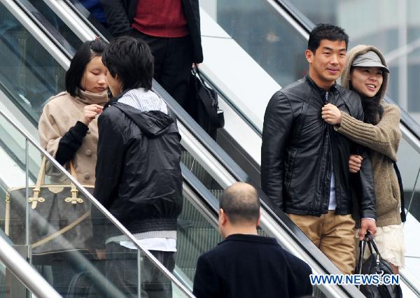 People stroll in streets as usual in Shanghai, east China, March 14, 2011. 