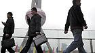 Pedestrians pass through the Oriental Pearl TV Tower in Shanghai, east China, March 14, 2011.