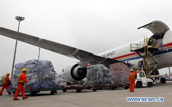Workers load relief materials to a plane at Shanghai Pudong International Airport in Shanghai, east China, March 14, 2011. 