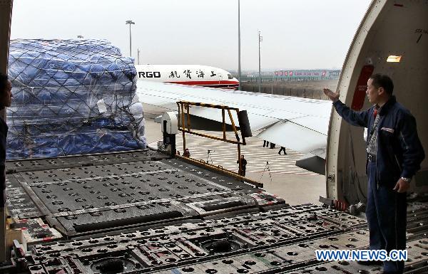 A worker guides the loading of relief materials at Shanghai Pudong International Airport in Shanghai, east China, March 14, 2011.