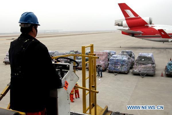 A worker operates to load relief materials to a plane at Shanghai Pudong International Airport in Shanghai, east China, March 14, 2011. 