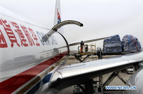 A worker loads relief materials to a plane at Shanghai Pudong International Airport in Shanghai, east China, March 14, 2011. 