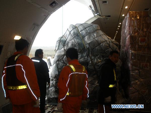 Staff members load relief goods offered by Chinese government to quake-hit Japan in to a plane in Shanghai Pudong International Airport in Shanghai, east China, March 14, 2011.