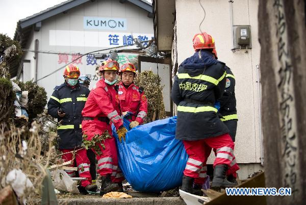 Members of the Chinese International Search and Rescue Team (CISAR) carry a victim's body at the quake-shaken Ofunato city in Iwate prefecture, Japan, March 15, 2011.